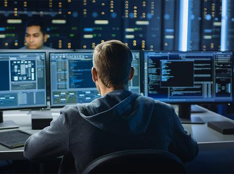 man coding in server room 
