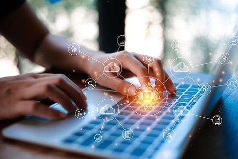 person typing on laptop with data and technology icons floating above circling AI icon