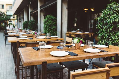 Restaurant outdoor dining, table set with plates, cutlery and glasses